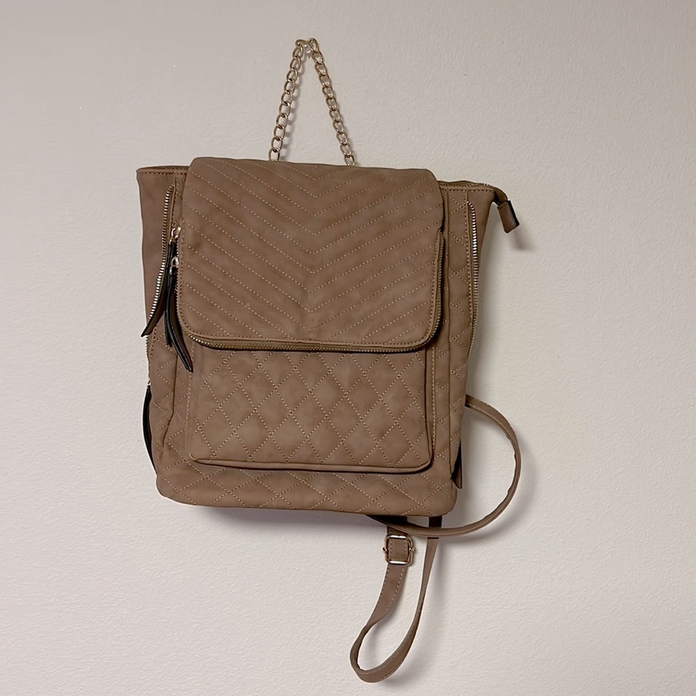 Backpack purse- tan. Flap has a zipper. Inside- 2 pockets and 1 zipper pocket
